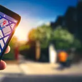 Dłoń trzyma smartfon z mapą i trasą. Dowiedz się, jak włączyć nawigację w telefonie, by łatwo dotrzeć do celu.