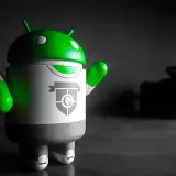 Zielony android na biurku, gotowy do pracy na PC.