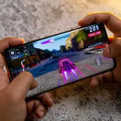 Ręce trzymają smartfon, na którym gra wyścigowa. Ten telefon do 2500 zł świetnie radzi sobie z grafiką.