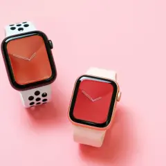Dwa zegarki Apple Watch na różowym tle. Jeden z białym paskiem w czarne kropki, drugi z jasnoróżowym. Czas na wymiana baterii Apple Watch.