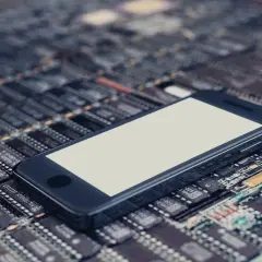 Smartfon leży na płytce drukowanej, symbolizując jego pamięć telefonu i zaawansowaną technologię.