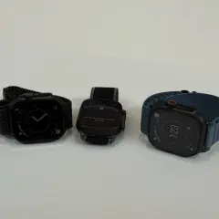 Trzy zegarki Apple Watch na białym tle: jeden z czarną bransoletą, drugi z czarną, trzeci z niebieską.