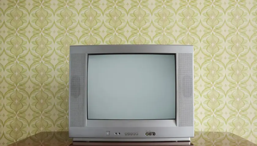 Stary kineskop na tle tapety w zielone wzory. Czekał na ulubiony program.