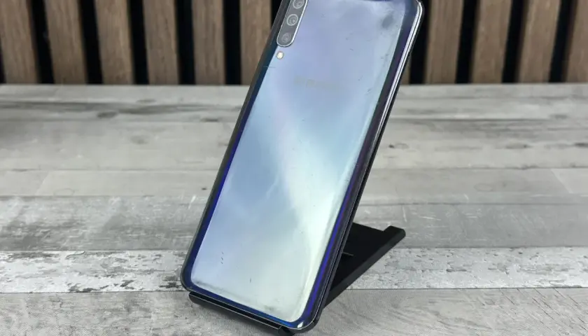 Telefon Samsung Galaxy A50 na czarnym stojaku, z widocznym logo Samsung. Sprawdź aktualną samsung galaxy a50 cena.