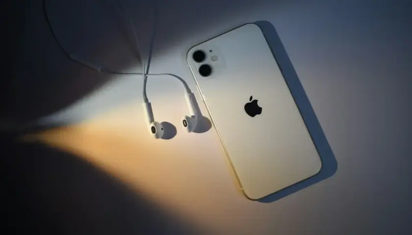 Biały iPhone 11 z słuchawkami, gotowy na premierę.