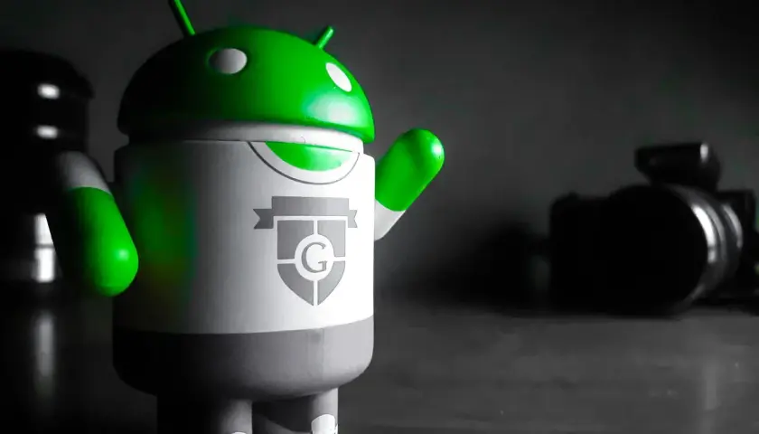 Zielony android na biurku, gotowy do pracy na PC.