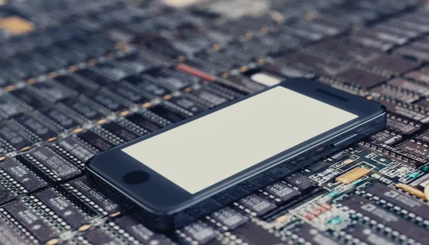 Smartfon leży na płytce drukowanej, symbolizując jego pamięć telefonu i zaawansowaną technologię.