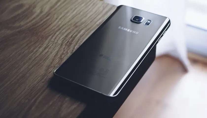 Czarny Samsung leży na drewnianym blacie. Chcesz wiedzieć, jak zresetować Samsung?