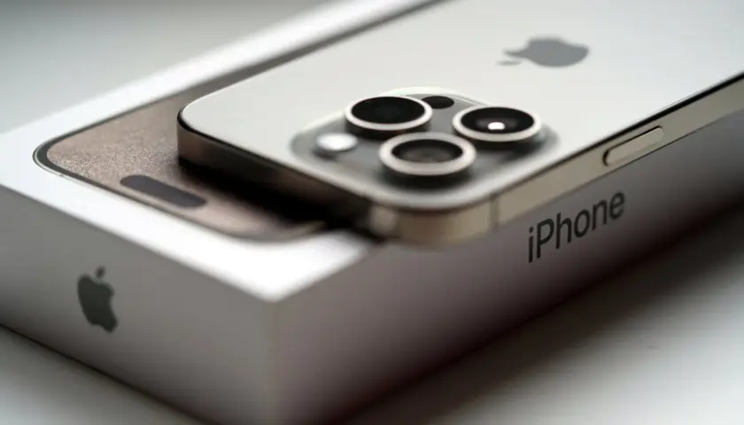 Nowy iPhone 15 na pudełku. Zbliżenie na moduł aparatów i logo Apple. Poznaj jego wymiary.