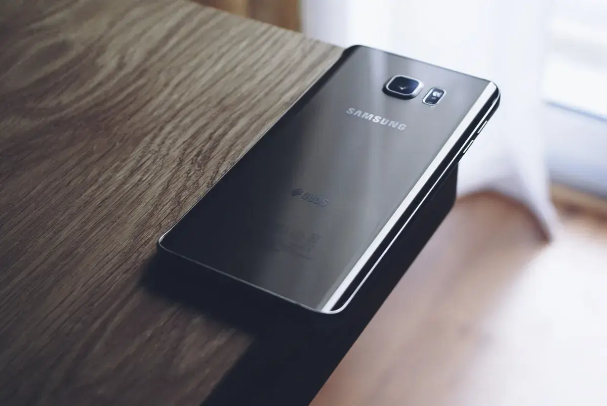 Czarny Samsung leży na drewnianym blacie. Chcesz wiedzieć, jak zresetować Samsung?